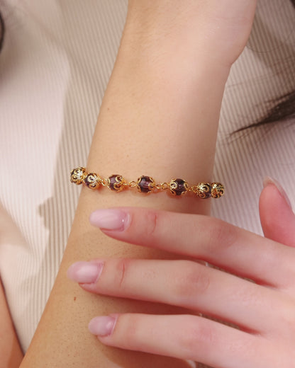Bracelet doré avec petites perles de cristal violettes et capuchons de perles en filigrane
